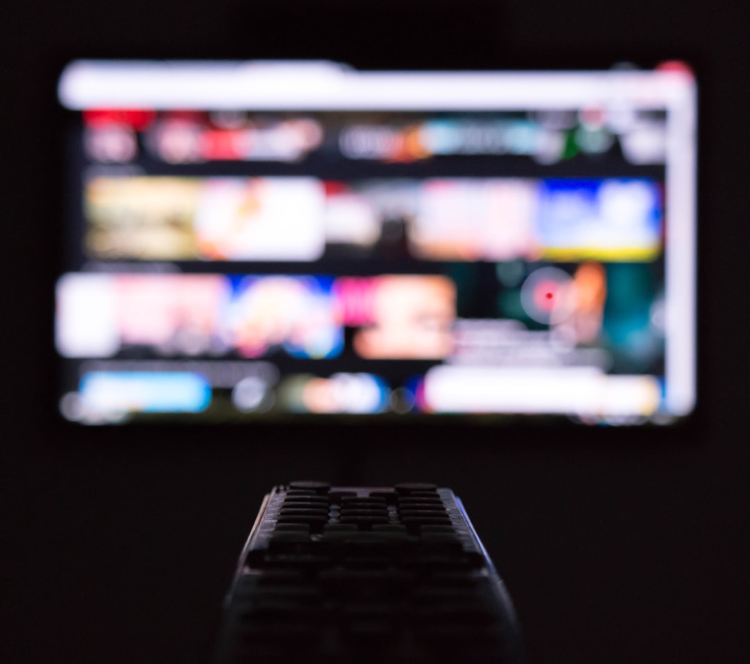 a-remote-control-sitting-in-front-of-a-television-yjxatmcpdgs